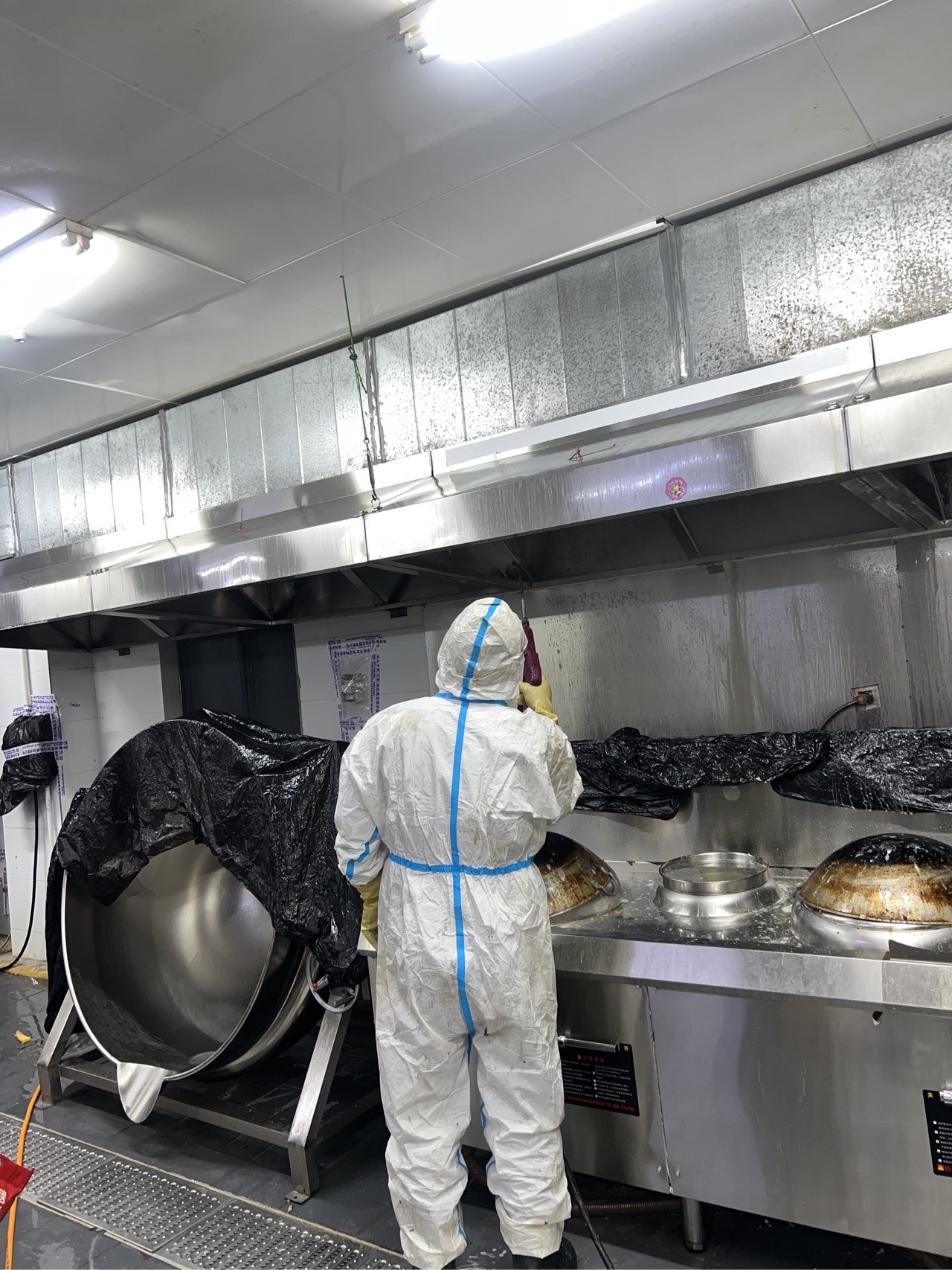 天得一商用厨房油烟设备清洗现场图1，参考新疆烧烤店后厨清洗场景